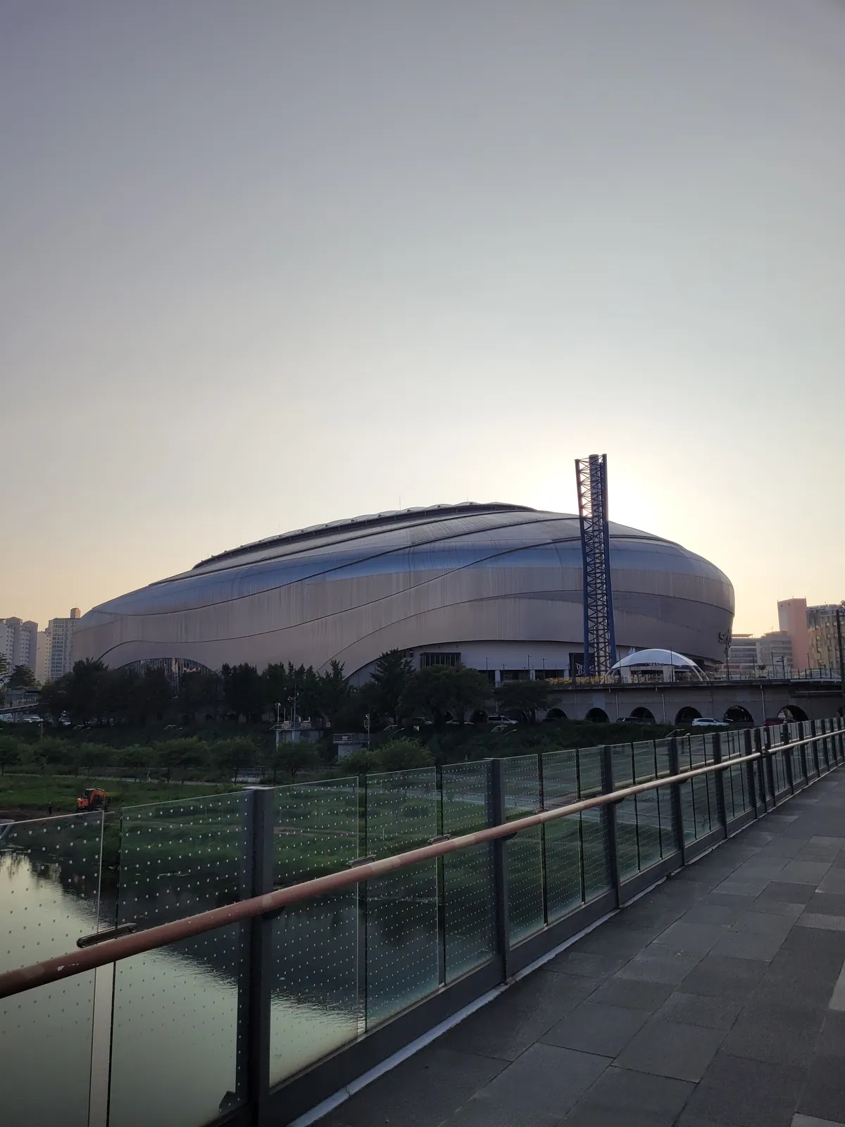 The domed silhouette of Gocheok Sky Dome at sunset, seen from the riverside walkway