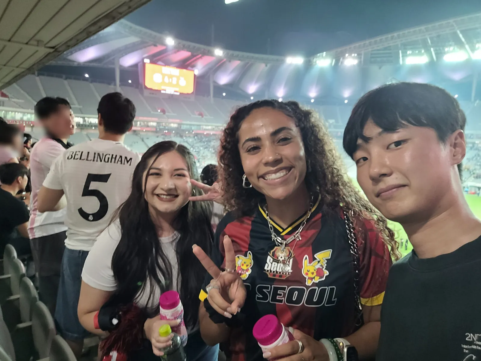 HanBuddy guests and their local buddy smiling in the stands under the Seoul World Cup Stadium floodlights